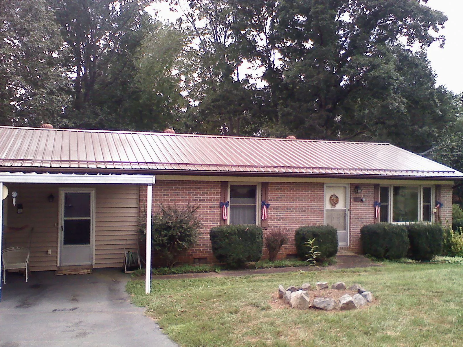 Bronze metal roof and carport on a brick ranch home — Roof Repair work by our crew in Earling